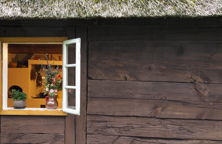 old country window with flowers in a vaseの写真素材