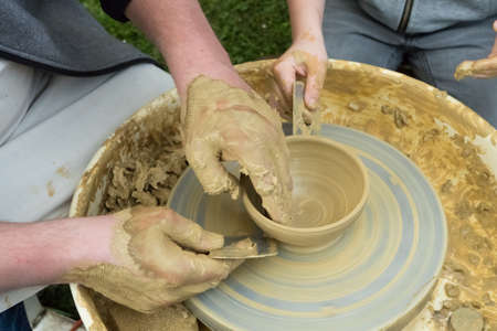 master and apprentice - learning how to make a clay bowlの写真素材