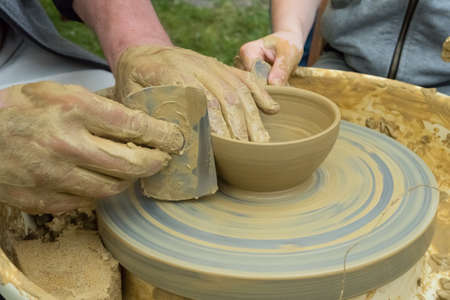 master and apprentice - learning how to make a clay bowlの写真素材