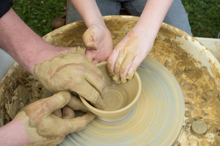 master and apprentice - learning how to make a clay bowlの写真素材