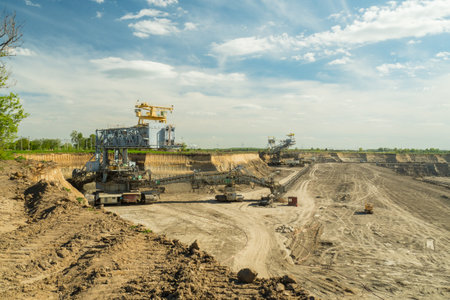 Industrial view of opencast mining quarry with machinery at work. Area has been mined for copper, silver, gold, and brown coal mine. Bucket-wheel excavator mining in a open pit brown coal mine.の写真素材