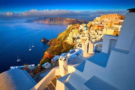 Oia town on Santorini island, Greece. Traditional and famous houses and churches with blue domes over the Caldera, Aegean sea. Oia village in the morning light, Santorini. Amazing sunrise view with white houses in Oia village.の写真素材
