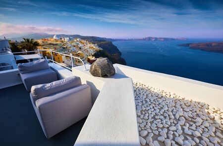 Wonderful view from the balcony of the hotel on Oia village in the morning light, Santorini, Greece. Traditional and famous houses and churches with blue domes over the Caldera, Aegean sea.  Amazing sunrise view with white houses in Oia village.の写真素材
