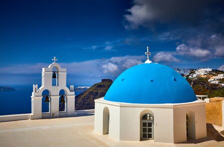 Oia town on Santorini island, Greece. Traditional and famous houses and churches with blue domes over the Caldera, Aegean sea. Oia village in the morning light, Santorini. Amazing sunrise view with white houses in Oia village.の写真素材