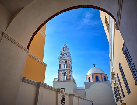 Fira town on Santorini island, Greece. Traditional and famous houses and churches and monastery over the Caldera, Aegean sea. Oia village in the morning light. Amazing sunrise view on Santorini's streetの写真素材