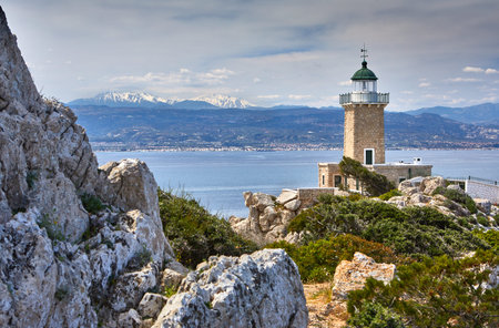 Melagkavi Lighthouse also known as Cape Ireon Light perching high on a headland overlooking eastern Gulf of Corinth, Greece. Bright sunny view of spring seascape, Cape Melagavi.の写真素材