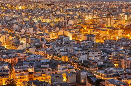 An evening cityscape of many buildings of Athens City, Greece. View from Filopappou Hill or Hill of the Muses. Colorful spring landscape. Urban skyscraper skyline rooftop view at night.の写真素材