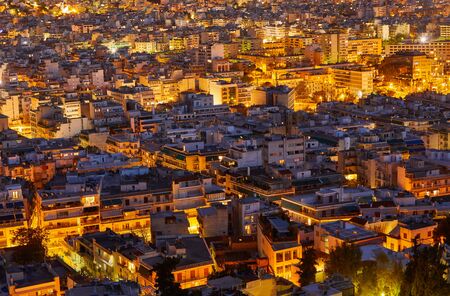 An evening cityscape of many buildings of Athens City, Greece. View from Filopappou Hill or Hill of the Muses. Colorful spring landscape. Urban skyscraper skyline rooftop view at night.の写真素材