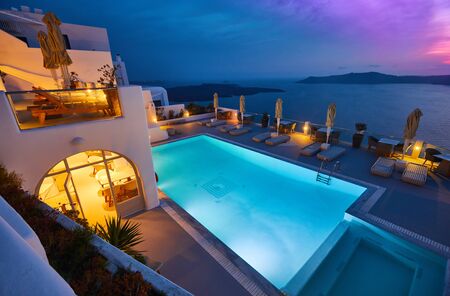 Swimming pool on the hotel terrace of fira's town on Santorini island, Greece. Incredibly romantic sunset on Santorini. Oia village in the morning light. Amazing sunset view with white houses. Island loversのeditorial素材