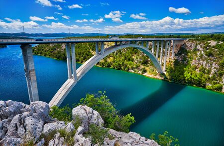 Sunlight view on the Sibenik Bridge a long concrete arch bridge passing through the canyon of the Krka River. Location Skradin town, Croatia, Europe. Scenic image of travel destination. Discover the beauty of earth.の写真素材