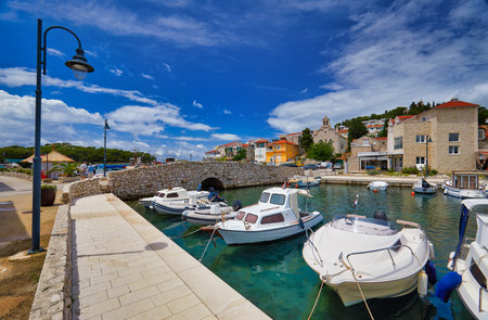 Fishing and sailing boats at the harbor. Sunny summer view of Tribunj port. Morning seascape,...