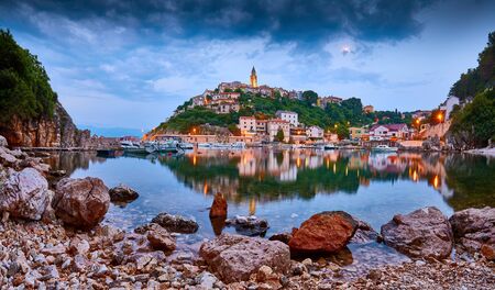 Town of Vrbnik (Verbnik) harbor view morning glow, Island of Krk, Kvarner bay archipelago, Croatia, Europe. Dramatic summer seascape of Adriatic sea. Stone beach. Incredible evening cityscape in the moon light.の写真素材