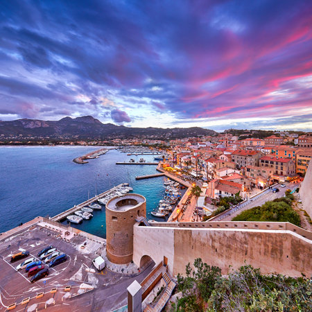View from the walls of the citadel of Calvi on the old town with historic buildings at evening...