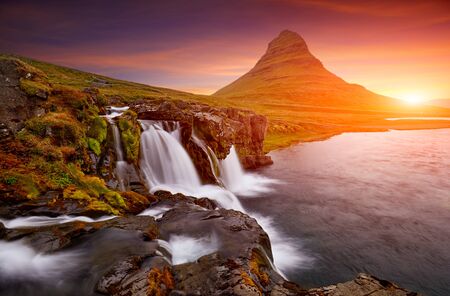 Colorful sunrise on Kirkjufellsfoss waterfall. Amazing morning scene near Kirkjufell volkano, Iceland, Europe. A famous tourist attraction near the city of Grundarfjordur. Travel concept background.の写真素材