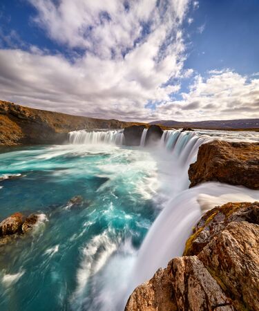 Panorama of most famous place of Golden Ring Of Iceland. Godafoss waterfall near Akureyri in the Icelandic highlands, Europe. Popular tourist attraction. Travelling concept background. Postcard.の写真素材