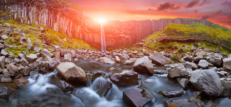 Colorful clouds over Svartifoss waterfall. Iceland, Europe. Basalt columns formation. Popular tourist attraction. Travelling concept background. Golden Ring Of Iceland. Postcard.の写真素材