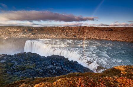Rainbow over Dettifoss is the most powerful waterfall on Iceland and in the Europe. Jokulsargljufur National Park, Jokulsa a Fjollum river. Popular tourist attraction. Travelling concept background.の写真素材