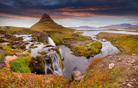 Colorful sunrise on Kirkjufellsfoss waterfall. Amazing morning scene near Kirkjufell volkano, Iceland, Europe. A famous tourist attraction near the city of Grundarfjordur. Travel concept background.の写真素材