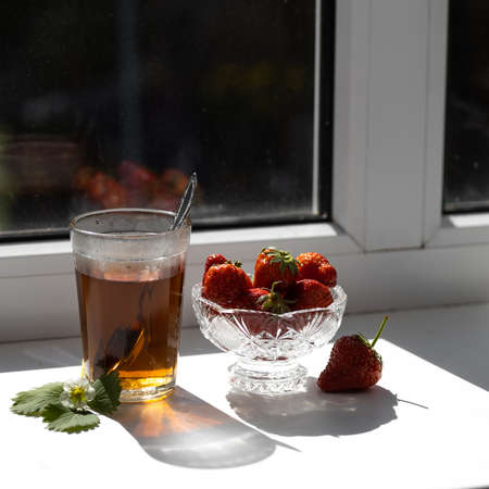 Cup of tea and strawberries on a white lace backgroundの写真素材