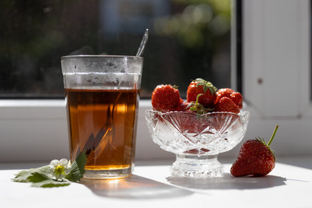 Cup of tea and strawberries on a white lace backgroundの写真素材
