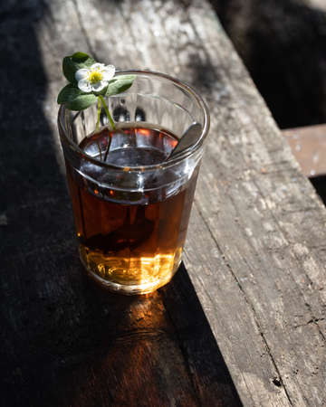 Cup of tea and wild strawberries on a wooden backgroundの写真素材