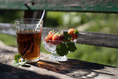 Cup of tea and wild strawberries on a wooden backgroundの写真素材
