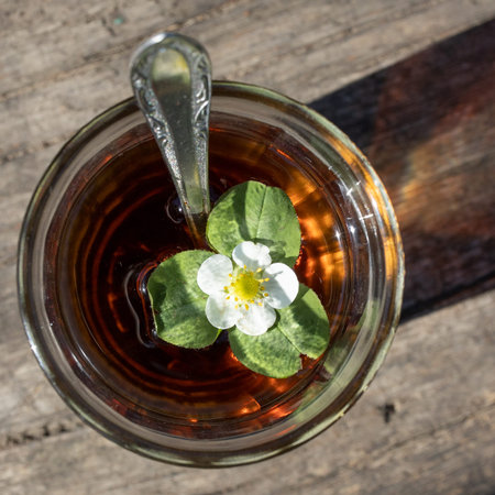 Cup of tea and wild strawberries on a wooden backgroundの写真素材