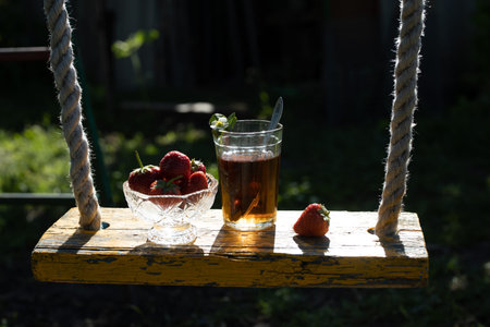 Cup of tea and wild strawberries on a wooden backgroundの写真素材