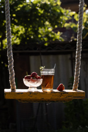 Cup of tea and wild strawberries on a wooden backgroundの写真素材