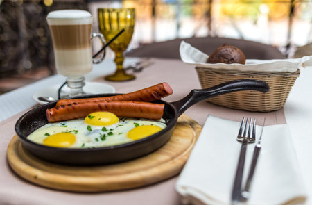 delicious breakfast of scrambled eggs with sausage in a restaurantの写真素材