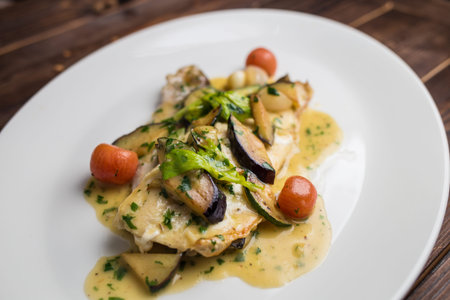 fish fillet with zucchini and tomatoes in a creamy sauceの写真素材