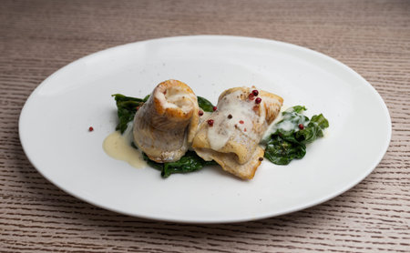fish fillet in a creamy sauce with spinachの写真素材