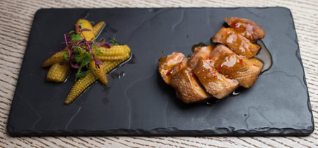 duck breast with sweet corn on a small boardの写真素材