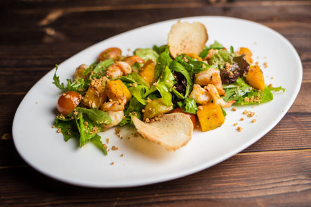 Salad with seafood and vegetable marrow decorated with croutonsの写真素材