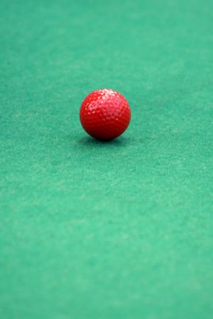 Red golf ball on a mini golf putting greenの写真素材