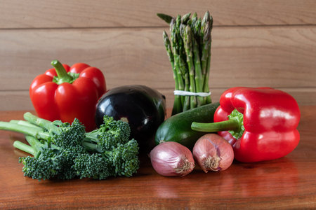 Front view of raw vegetables. Fresh ball peppers, onion, aubergine, courgette and asparagus on...