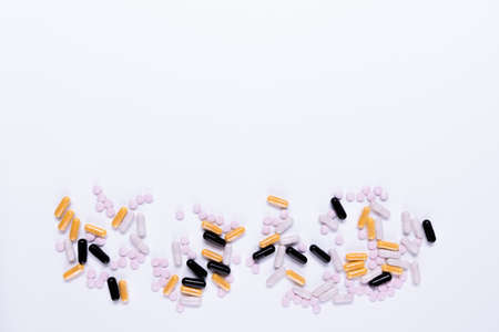 Small ping tablets scattered on white background ,Taking medication, pills. Nutritional supplementの写真素材