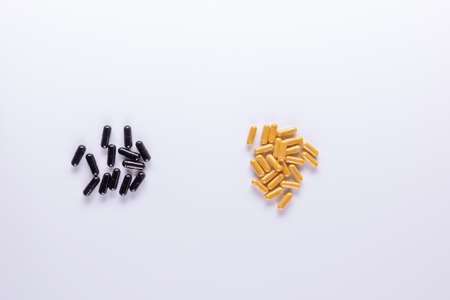 Yellow , black, tablets and capsules lying on white background close-up. Omega 3, Multivitamins, Calcium, Antibiotics. Health. Immunity. Taking medication, pills. Nutritional supplement Copy spaceの写真素材