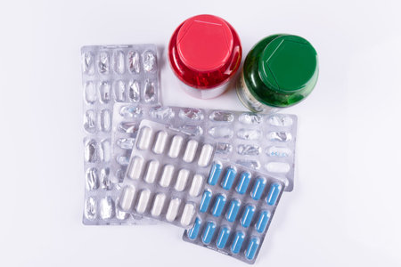 Old and used pills blisters packaging, empty, opened and unused with green and red botles containers, health care and medicines concept. Pharmaceutical industry. Pharmacy.の写真素材
