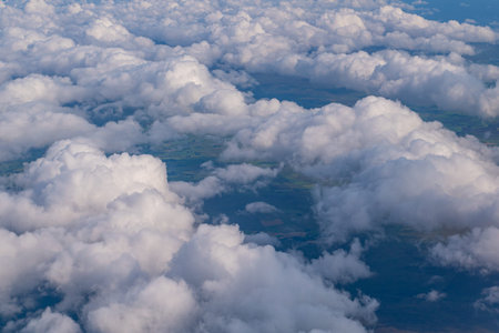 Clouds view from the sky with visible part of land below