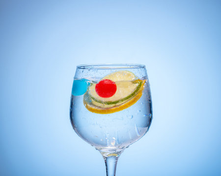 glass of water with lemon and colored ice balls .の写真素材