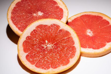 Three slices of a grapefruit isolated on white background. Round slice of fresh fruit.