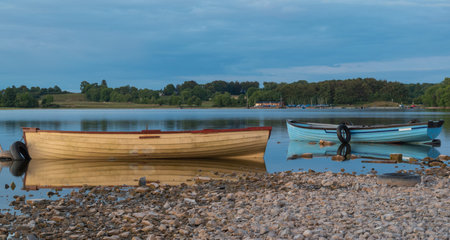 Boat on the lake with reflection in the water at sunset