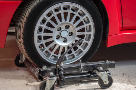 Red car on hidraulic wheel skates for easy moving .