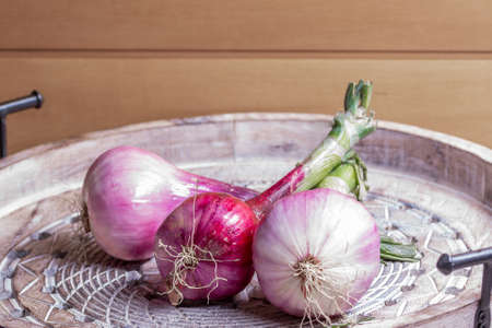 New season purple onions on wooden tray.の写真素材