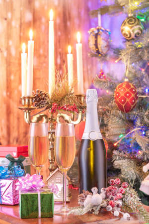 Glasses of champagne and gifts composition with lit up candelabra .の写真素材