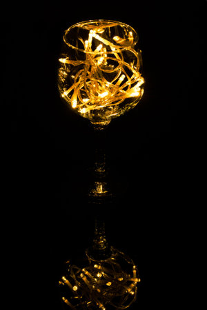 Fairy Light in a wine glass, in the Dark, Low-Key Photography.の写真素材