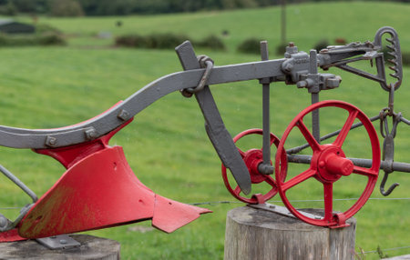Old restored vintage plow sitting on wooden pedestal.の写真素材