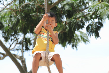 Japanese boy playing with Tarzan ropeの写真素材