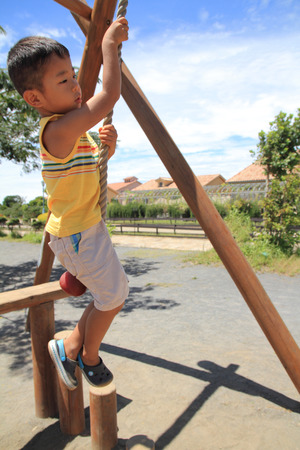 Japanese boy playing with Tarzan ropeの写真素材
